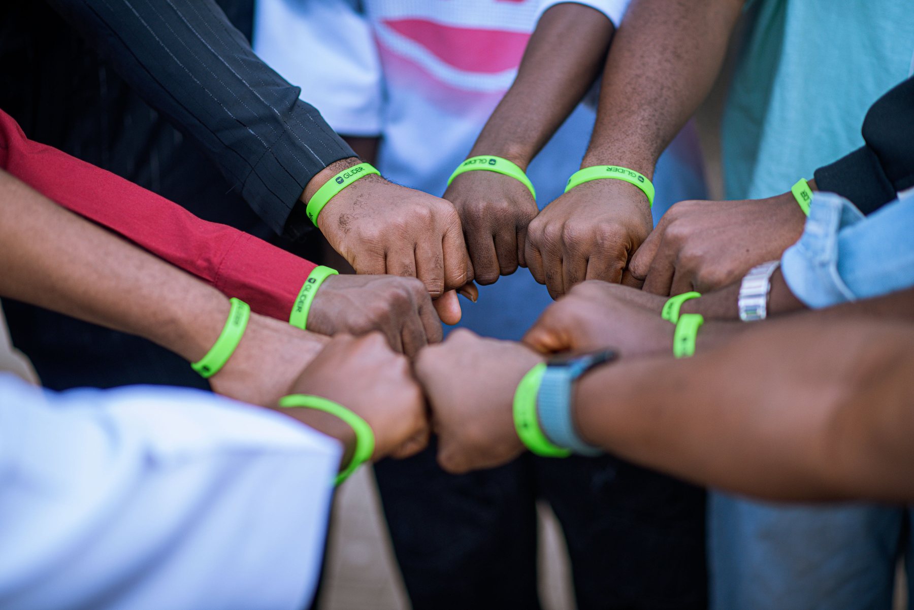 Glider community members placing their hands together in a huddle
